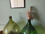 two green vases sitting on a table next to each other