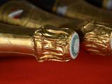three bottles of champagne are lined up on a red surface