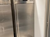two stainless steel refrigerators next to each other in a room