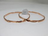une paire de bracelets dorés ornés d'un motif gravé