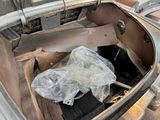 an old car with a plastic bag in the trunk