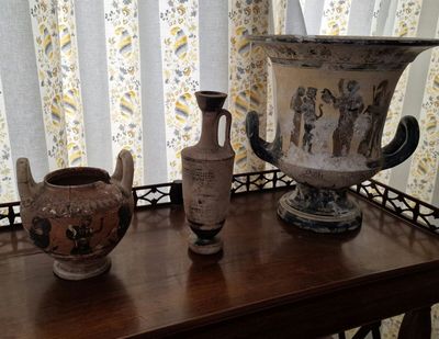 trois vases posés sur une table devant une fenêtre