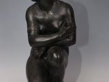 bronze statue of a woman sitting on a rock