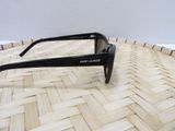 sunglasses on a woven basket with a white wall in the background