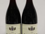 two bottles of red wine sitting next to each other on a table
