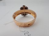 a gold ring with a flower on it on a table