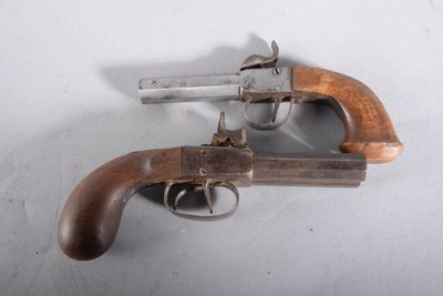 un vieux pistolet avec une poignée en bois sur une surface blanche