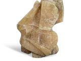 a stone sculpture of a man sitting on top of a rock