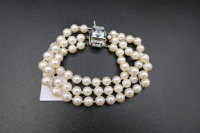 un gros plan d'un bracelet orné de perles sur un fond noir