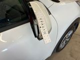 a white car with a parking ticket attached to it ' s side mirror