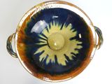 a blue and yellow bowl sitting on a white surface