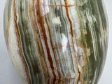 a green and brown marble ball sitting on a white surface