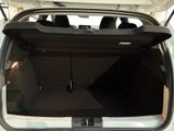 the back of a white car with its trunk open and the door open