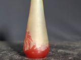 a red and white vase sitting on a marble table