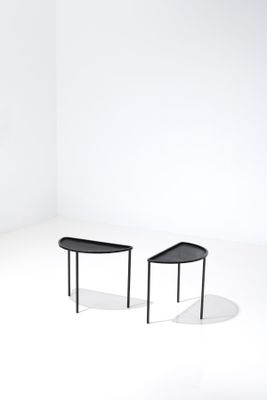 two black tables sitting on top of a white floor next to each other