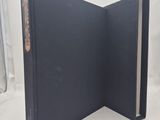 an open book with a black cover sitting on a white surface