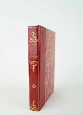 un vieux livre rouge posé sur une surface blanche