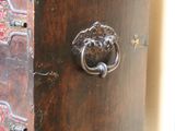a small wooden chest with a lion head on it