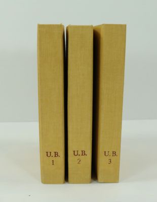 trois livres superposés sur une surface blanche