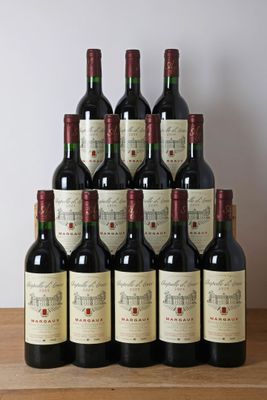 des bouteilles de vin rouge sont posées sur une table en bois devant un mur blanc