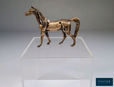 statue d'un cheval dans une boîte transparente posée sur une surface blanche