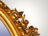 a mirror with a gold frame and flowers on it