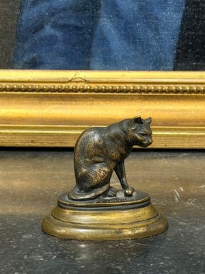 une statue représentant un chien assis sur un socle devant un miroir