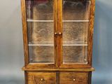 a wooden display cabinet with glass doors and drawers