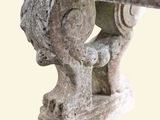 a close up of a stone bench with a head on it