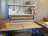 une pièce remplie de cartons et une table sur laquelle se trouve un rouleau de papier