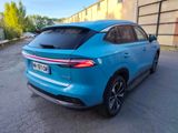 the rear end of a blue car parked in a parking lot