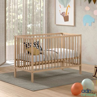 a baby crib in a room with balloons on the floor