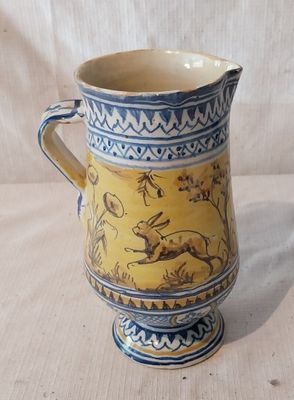 un vase jaune et bleu orné d'un lapin
