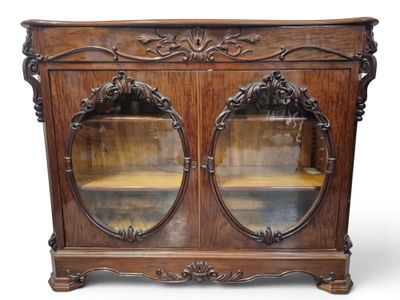 une vieille armoire en bois surmontée de deux portes vitrées