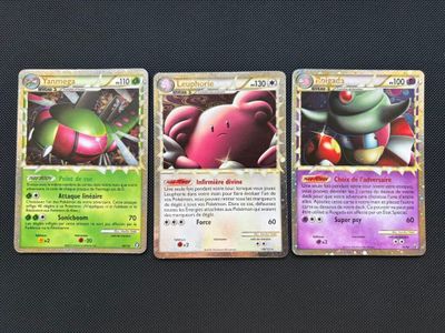 three pokemon cards are sitting on top of a table