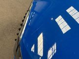 a close up of a blue car parked on the side of the road