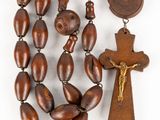 a close up of a wooden rosary with a wooden cross on it