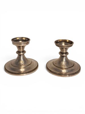 a pair of silver candlesticks on a white background