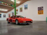 une voiture de sport rouge garée dans une grande pièce