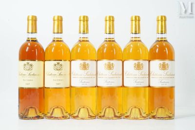 six bouteilles de vin sont alignées sur une surface blanche