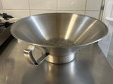 a large metal bowl sitting on a counter in a kitchen