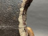 a close up of a piece of metal with a piece of wood sticking out of it