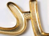 a close up of a gold letter k on a white surface