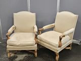 une paire de fauteuils rembourrés de couleur crème dans une pièce séparée par une cloison