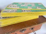 a stack of yellow and green cards sitting on top of a suitcase