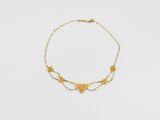 gros plan d'un collier en or sur une surface blanche