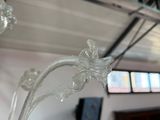 un vase en verre orné d'une fleur, posé devant une fenêtre