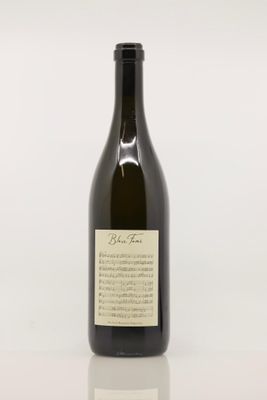 une bouteille de vin posée sur une table à côté d'un verre