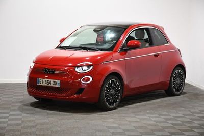 Une Smart rouge est garée dans une pièce dont le sol est en damier.