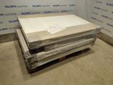 Des cartons contenant des matelas sont empilés sur une palette dans une pièce